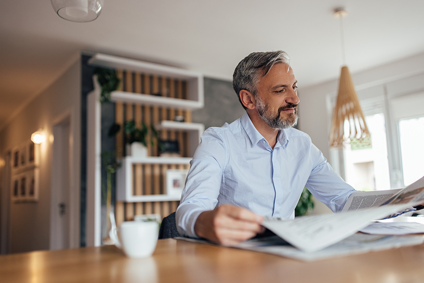 Adult man, enjoying his day off, while drinking coffee and reading.
